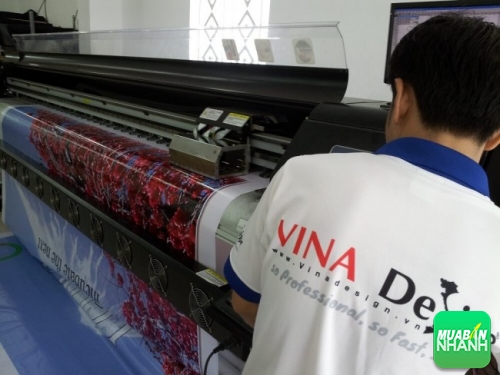 Nhân viên in ấn InHiflex đang điều chỉnh máy in và giám sát thành phẩm in phông nền trên bạt hiflex khổ lớn cho khách hàng